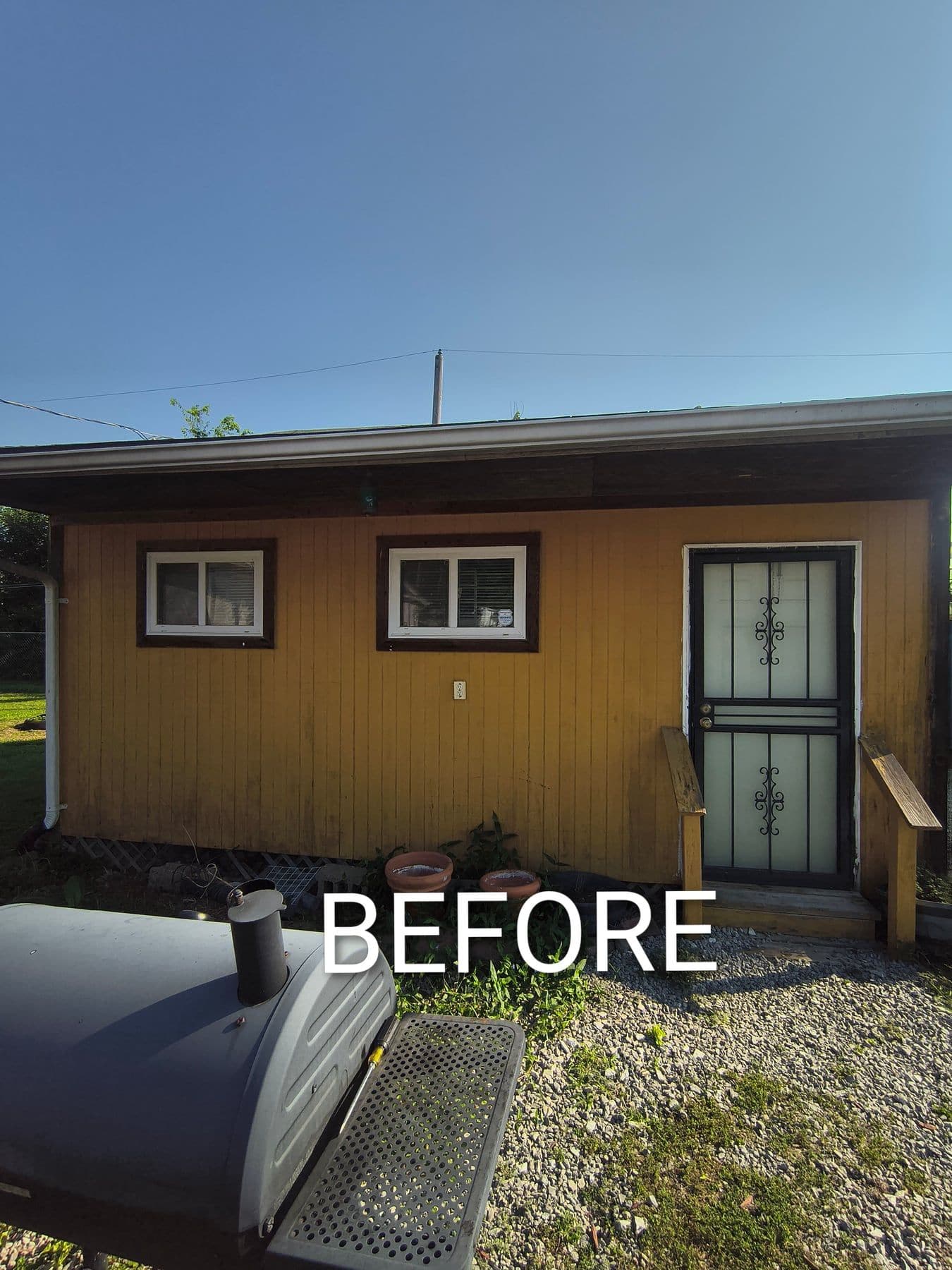 Garage exterior before repainting, with faded yellow siding