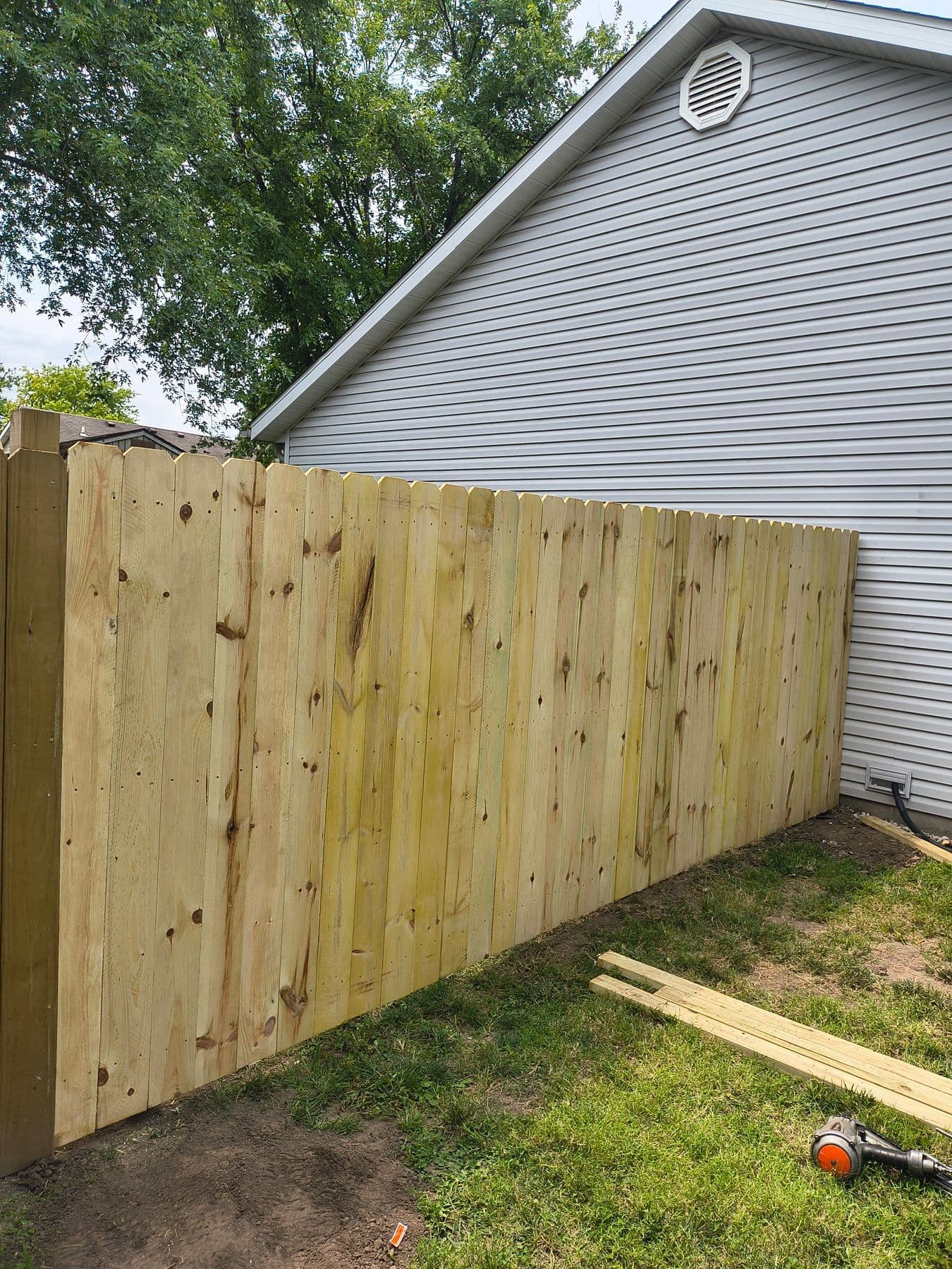 New wood privacy fence along the side of a house